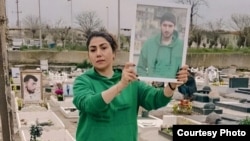 فرزانه برزه‌کار با لباس پسرش عرفان بر سر مزارش