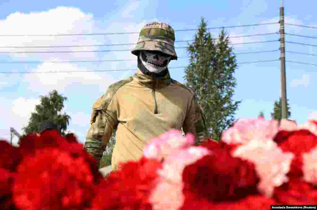 Наёмник частной военной компании «Вагнер» у стихийного мемориала возле «Вагнер-центра» после гибели основателя ЧВК Евгения Пригожина, Санкт-Петербург, Россия, 24 августа 2023 года. Частный самолёт Пригожина потерпел крушение над Тверской областью. Он погиб. За два месяца до этого Пригожин и его наёмники предприняли попытку мятежа против руководства Минобороны. Президент России Владимир Путин сначала обвинил ЧВК в госизмене, против Пригожина возбудили дело о вооружённом мятеже. После переговоров удалось договориться об отходе наёмников на белорусскую территорию. Путин пообещал прекратить преследование мятежников. Позже, комментируя крушение самолёта Пригожина, Путин намекнул, что борт взорвался изнутри по причине неосторожного обращения с боеприпасами. REUTERS/Anastasia Barashkova