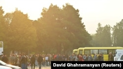 Residents gather next to buses in central Stepanakert before leaving Nagorno-Karabakh, September 25, 2023.