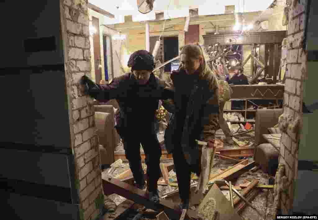 Полицейский помогает постоялице отеля. «Две ракеты попали в гостиницу в центре Харькова. Военных там не было. Было 30 мирных жителей, 11 из которых получили ранения», — написал в Telegram'е мэр города Игорь Терехов