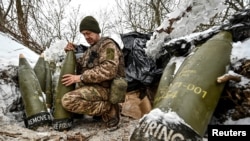 Український військовослужбовець готує 155-мм артилерійські снаряди на позиції біля лінії фронту, Запорізька область, 14 січня 2024 року