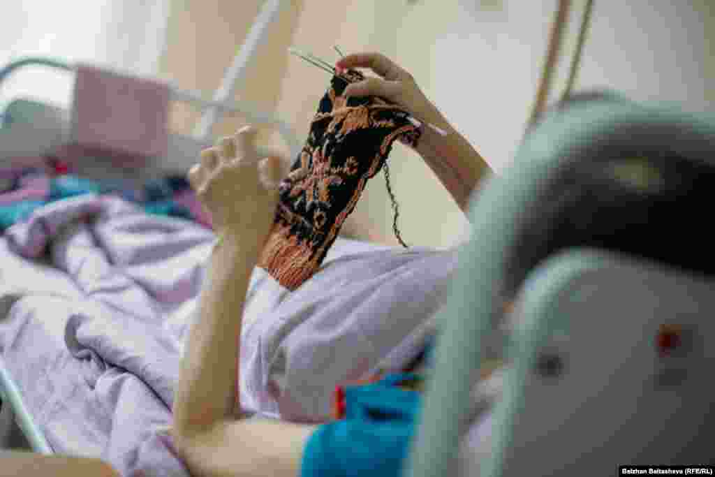 Хосписте жатқан науқас. Дауасыз дертіне қарамастан бұл әйел ұлына алаңдайды. Қазір ол ұлына шұлық тоқып жатыр. 