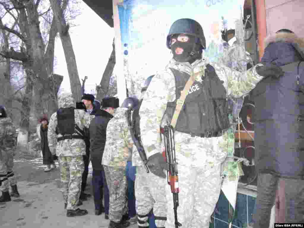 Полицейские обыскивают задержанных в ходе волнений мужчин. 