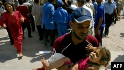 یک عراقی در حال بردن دختر مجروح خود به بیمارستانی در کرکوک در روز شنبه