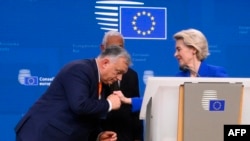 Прем'єр-міністр Угорщини Віктор Орбан цілує руку президентці Єврокомісії Урсулі фон дер Ляєн після спільної пресконференції. Брюссель, 20 грудня 2024 року
