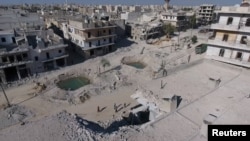 Syria -- A still image taken on September 27, 2016 from a drone footage obtained by Reuters shows people standing near craters and damaged buildings in a rebel-held area of Aleppo,