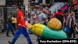 Москвадагы базарлардын биринде жүк сүйрөгөн мигрант.