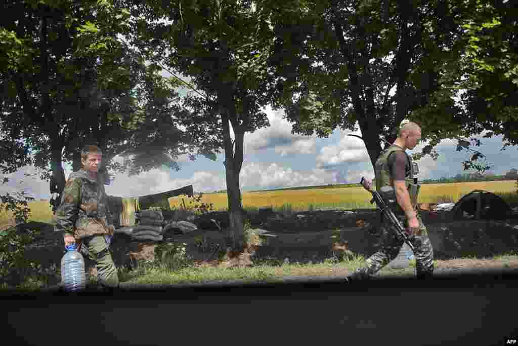 Українські солдати йдуть по воду повз бойові позиції на КПП біля Слов’янська, 11 червня 2014 року