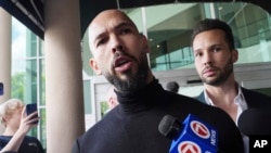 Andrew Tate (centru) și Tristan Tate sosind joi în Statele Unite.