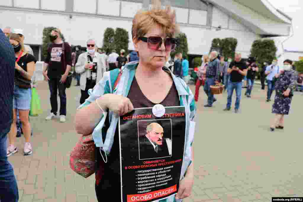 Протестувальниця на мітингу 7 червня в Мінську тримає портрет чинного президента Білорусі Олександра Лукашенка з написом: «Зупиніть злочинця» 