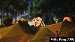 Протестующий в маске принимает участие в акции протеста в округе Ванчай в Гонконге, 4 октября 2019 года