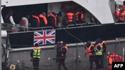 Migranți care au traversat Canalul Mânecii sunt preluați de poliție la Dover, în Anglia, la 5 februarie 2025. Potrivit noilor reguli, ei au șanse minime să devină vreodată cetățeni britanici.