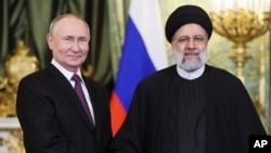 Володимир Путін та Ебрагім Раїсі тиснуть руки в Кремлі. 7 грудня 2023 року