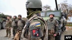Українські бійці 155-ї окремої механізованої бригади стоять біля військової техніки під час навчань у Франції 
