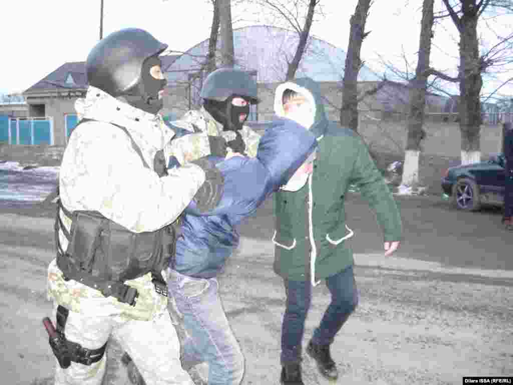 Полиция ведет задержанного в ходе волнений и последовавших событий молодого человека. 