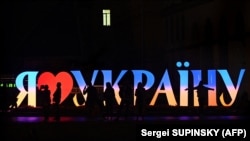 Люди проходять повз інсталяцію з написом «Я люблю Україну» на майдані Незалежності в Києві, 6 жовтня 2022 року
